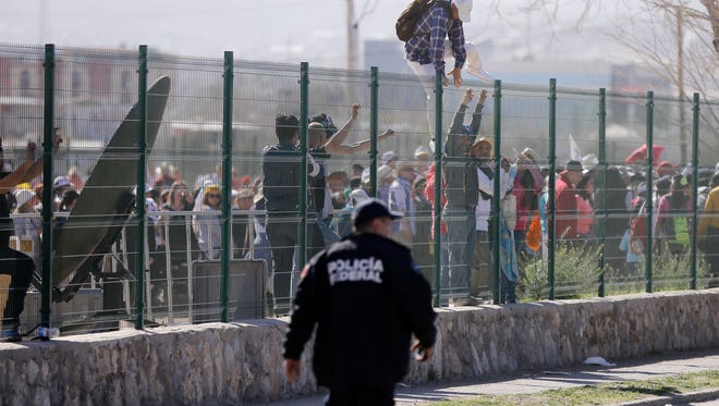 A man climbs over a fence to enter an outdoor Mass with Pope Francis in Ciudad Juarez, Mexico, Wednesday, Feb. 17, 2016. Pope Francis is scheduled to wrap up his trip to Mexico on Wednesday with some of his most anticipated events: a visit in a Ciudad Juarez prison just days after a riot in another lockup killed 49 inmates and a stop at the Texas border when immigration is a hot issue for the U.S. presidential campaign. (AP Photo/Gregory Bull)