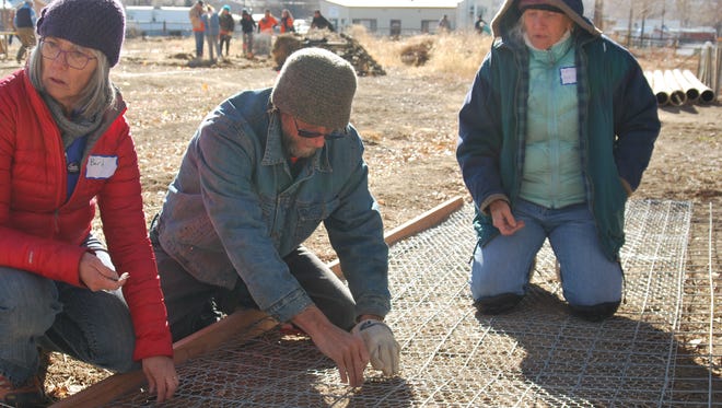 Volunteers Barb Luther, left, Vern Hensler and Kathy Hensler put together a wire fence for a chicken run at the New Beginnings community garden during the Farmington-Four Corners Martin Luther King Jr. Day of Service on Monday.