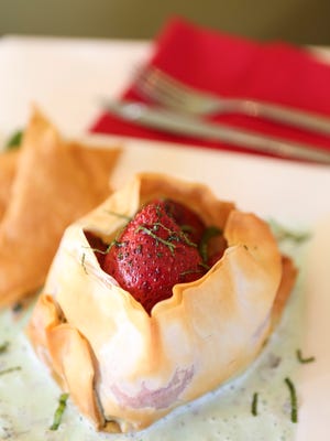 The baked strawberry purse dessert with mint sauce at the Olive Leaf Bistro in Jeffersonville, Ind.