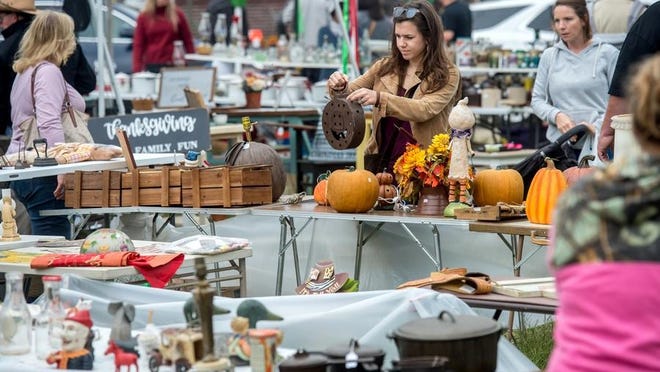 Customers work their way through tables teeming with items Saturday, Oct. 5, 2019, on the Spoon River Drive in London Mills.