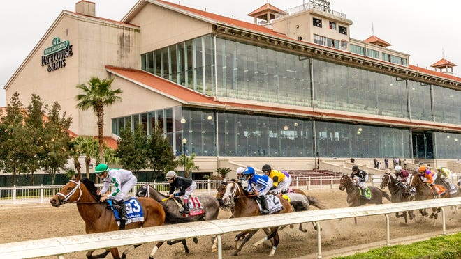 Wells Bayou, left, ridden by jockey Florent Geroux, took an early lead and held off NY Traffic to win he 107th running of the $1,000,000 Grade II Louisiana Derby horse race, Saturday, March 21, 2020, at a fanless Fair Grounds race course in New Orleans.  (Amanda Hodges Weir/Hodges Photography, Fair Grounds Race Course via AP)