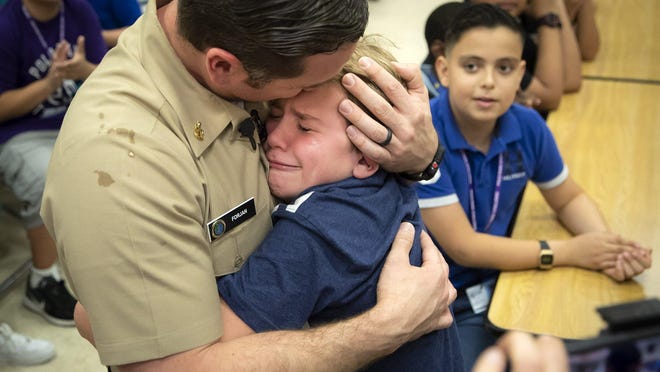 US Navy Senior Chief, Michael Forjan hugs his son, Gabriel, 11, a sixth-grader at Polo Park Middle School, Tuesday in Wellington on September 17, 2019. Forjan, who has been in Iraq since April, surprised his son by showing up unexpected in the school's cafeteria.