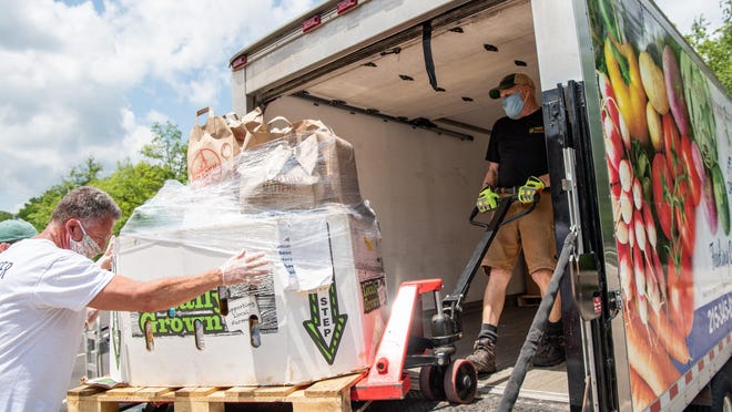 Andy Levine, left, a YMCA of Bucks County board member, helps Dennis Denard, a driver with the Bucks County Opportunity Council, load collected food into a box truck on Saturday. In addition to the 22,500 pounds collected at all four sites, the event raised more than $121,000 as of Saturday which will be used to purchase fresh produce, dairy and pantry staples and help with the cost of delivering these items directly to client's homes.