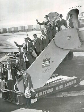 Iowa football players exit their plane after arriving