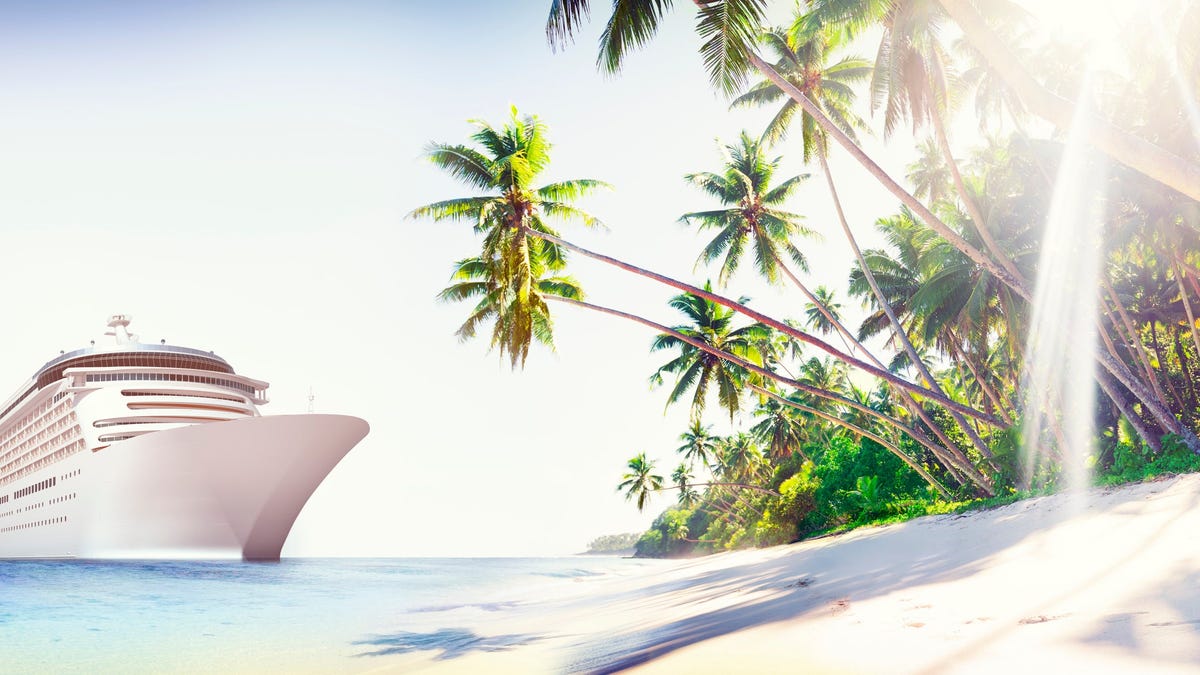 Cruise ship next to a beach with palm trees