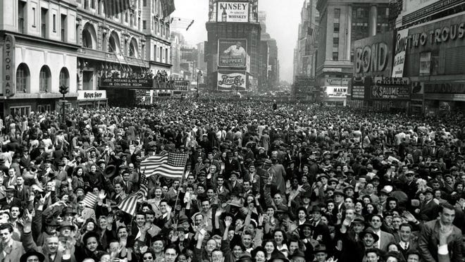 Looking north from 44th St., New York’s Times Square is packed with crowds celebrating the news of Germany’s unconditional surrender in World War II.