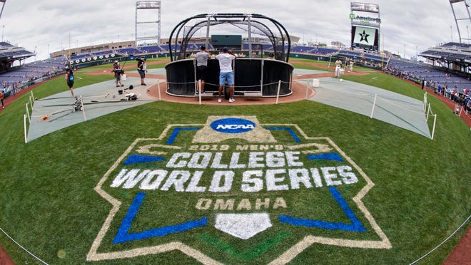 FILE - In this June 14, 2019, file photo, the College World Series logo is partially painted at TD Ameritrade Park in Omaha, Neb., as Vanderbilt players practice ahead of their College World Series game against Louisville. A group of Power Five coaches led by Michigan’s Erik Bakich is proposing a later start to the college baseball season to trim expenses in the post-coronavirus era, make the game more fan friendly and reduce injury risk to players. (AP Photo/Nati Harnik, File)