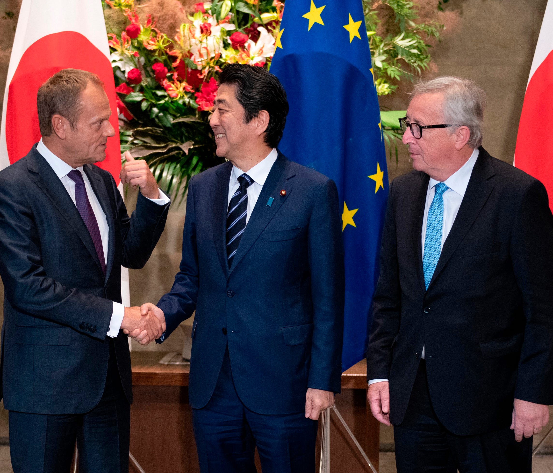Japanese Prime Minister Shinzo Abe, center, shakes hands with European Council President Donald Tusk next to European Commission President Jean-Claude Juncker, right, before a meeting at Abe's official residence in Tokyo Tuesday, July 17, 2018.