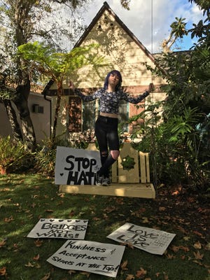 In this Monday, Nov. 21, 2016, photo, high school student Amellia Sones, 14, who helped organize a Ventura Boulevard protest after the presidential election, poses with her signs at her home in Los Angeles. Around the country, even as protests have waned, Democrats say the sting of loss has left an impact unlike any past presidential race, stirring previously passive citizens to push beyond their initial tears and angry Facebook posts following Donald Trump’s win. (AP Photo/Damian Dovarganes)