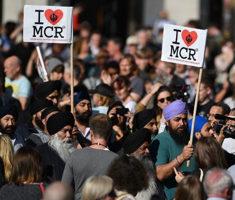 People from the Manchester Sikh community carry 