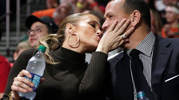 Jennifer Lopez, left, kisses Alex Rodriguez,...