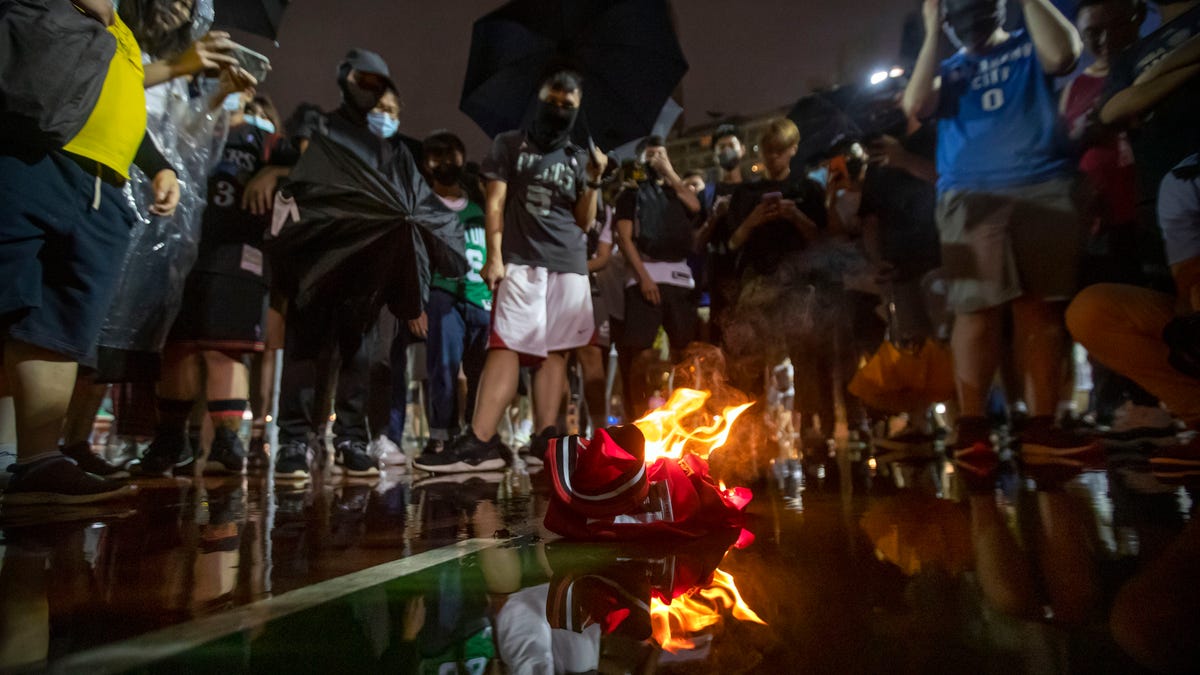 Demonstrators watch as a Lebron James jersey burns during a rally at the Southorn Playground in Hong Kong, Tuesday, Oct. 15, 2019. Protesters in Hong Kong have thrown basketballs at a photo of LeBron James and chanted their anger about comments the Los Angeles Lakers star made about free speech during a rally in support of the NBA and Houston Rockets general manager Daryl Morey, whose tweet in support of the Hong Kong protests   touched off a firestorm of controversy in China. (AP Photo/Mark Schiefelbein)