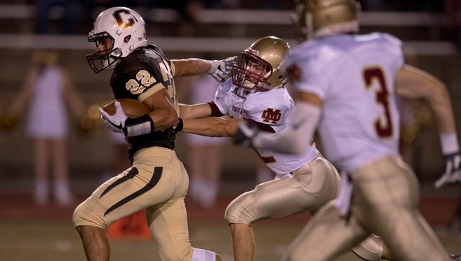 Central’s Reeder Pennell (22) tries to break the tackle of Mater Dei’s Clay Nosko (32) at Central Stadium Friday night.