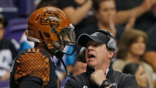 Rattlers head coach Kevin Guy talks to quarterback Nick Davila during a game against the Thunder at US Airways Center in Phoenix, AZ on April 18, 2015.
