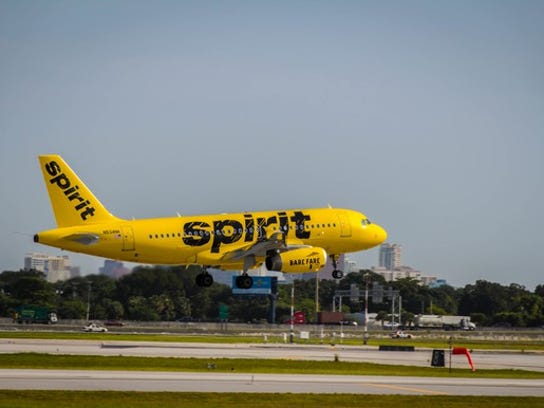 Exterior of landing Spirit A319 in bright yellow livery.