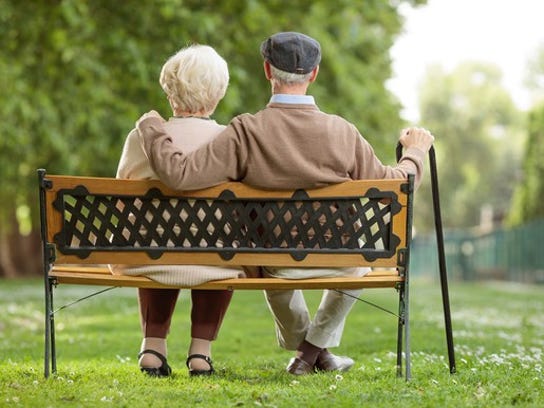 Older couple sitting on a park bench.