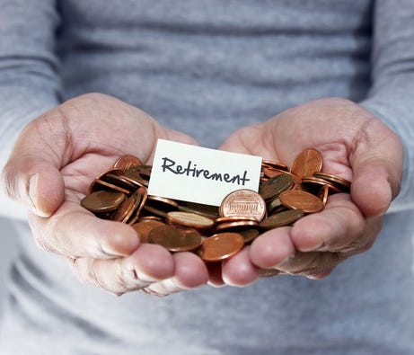 Man with his hands full of pennies and a small sign in the middle with the word Retirement