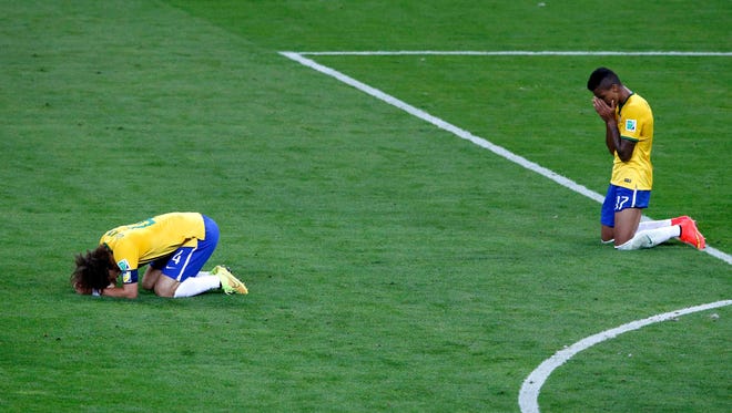 Brazil's David Luiz (L) and Luiz Gustavo react after losing their 2014 World Cup semifinals against Germany at the Mineirao stadium in Belo Horizonte July 8, 2014.
