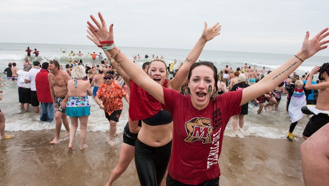 Crowds of swimmers flee the water just after the Penguin Swim in Ocean City on Friday Jan. 1, 2016.
