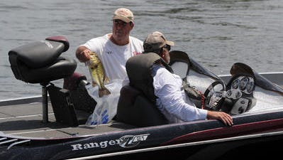 Ray Welch of Bossier City takes a bass out of the live well as he and his partner Phillip Brewster return from a morning of fishing during a past event on Cross Lake.