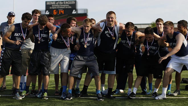 Bay Port track and field teammates huddle up before receiving the championship trophy for winning the Division 1 team title.