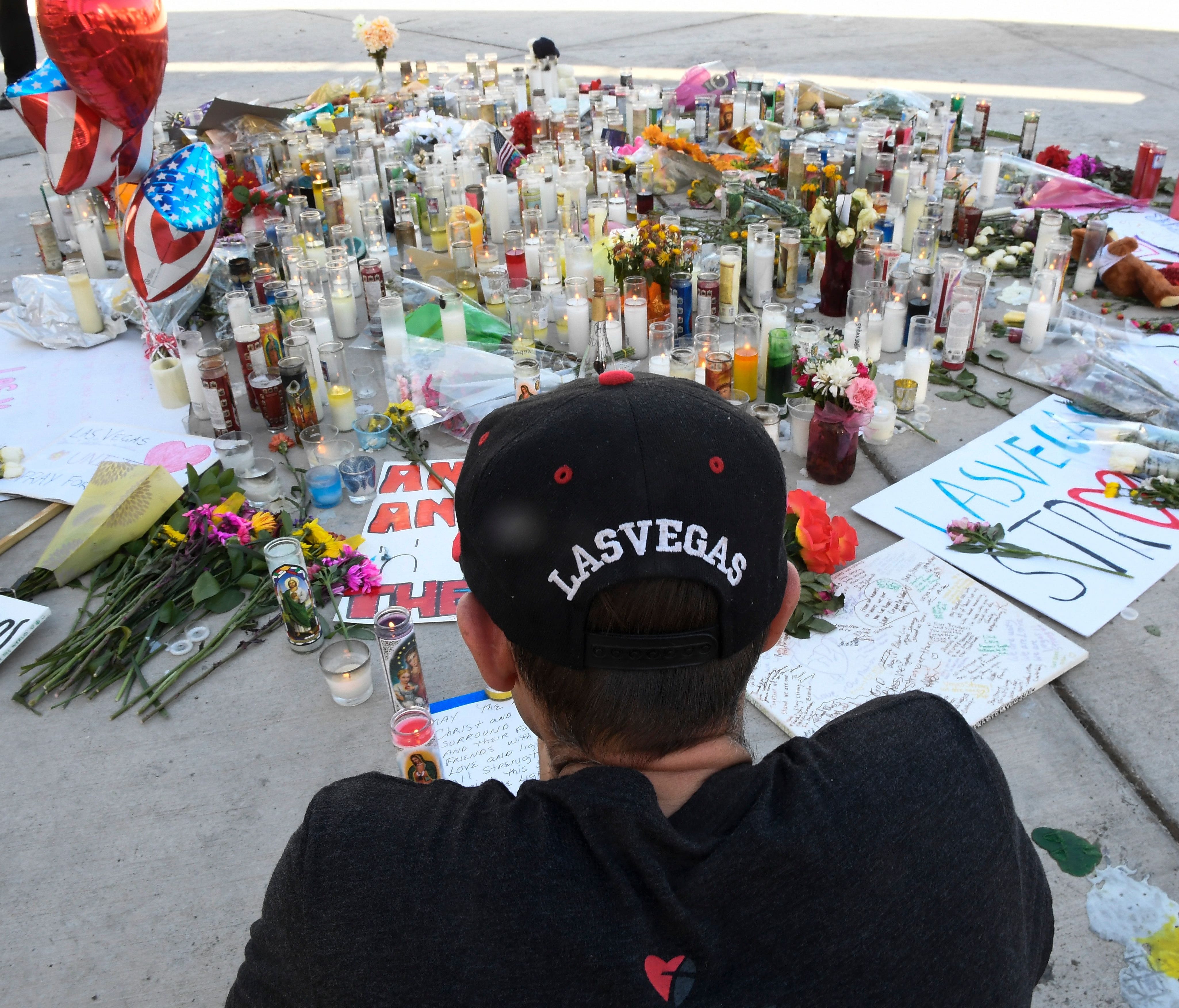 Ken Neyhart of Las Vegas, sits quietly at a makeshift memorial along Las Vegas Blvd. in Las Vegas, Nev. on Oct. 3, 2017.