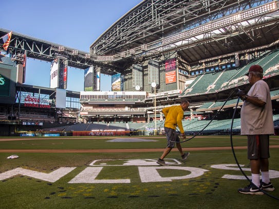 Brian Johnson paints the NLDS logo onto the field on