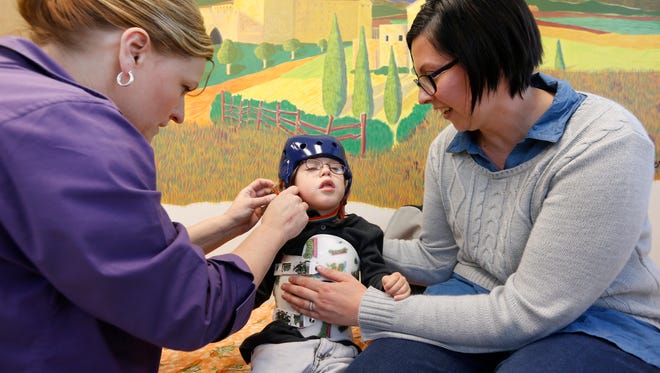 Certified Orthotist Mellissa Frietchen fits Ayden Markum, 3, for a helmet on Monday, Apr. 11, 2016. Ayden's mom Ashely Markum is gathering signatures for a petition to legalize medical marijuana to help her son who has seizures.