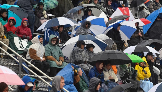 Harper Creek fans brave a steady rain to cheer on their team  during Saturday's  game against Muskegon.
