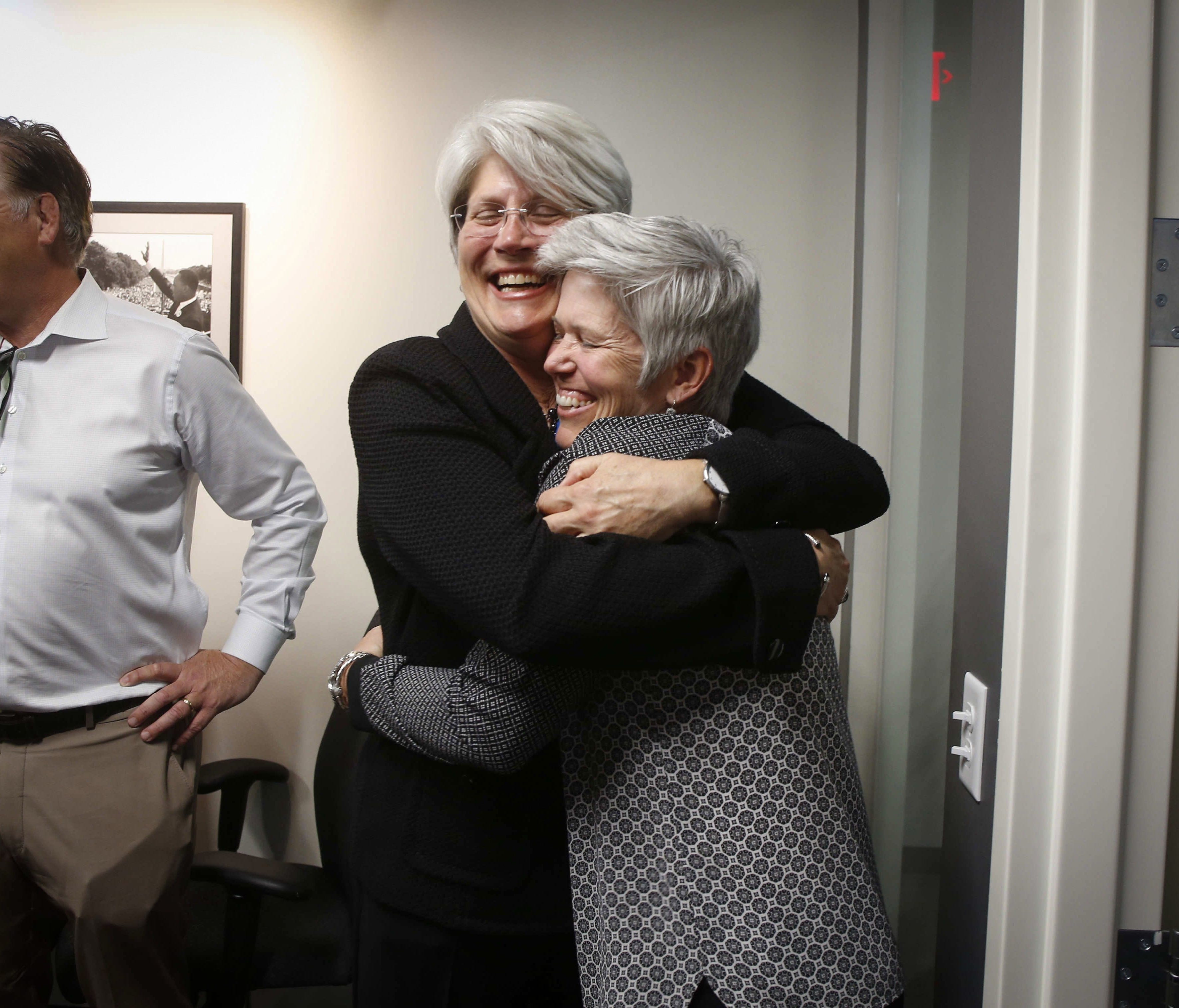 Former University of Iowa senior associate athletic director Jane Meyer, left, gets a hug after giving a press conference on Thursday, May 4, 2017.  A Polk County jury awarded Meyer a victory in her sexual discrimination lawsuit against the Universit