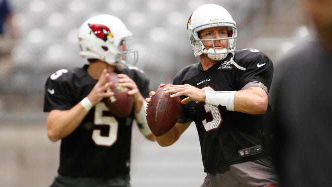 Cardinals quarterbacks Drew Stanton (left) and Carson Palmer throw during practice at University of Phoenix Stadium in Glendale on Thursday, August 27, 2015.