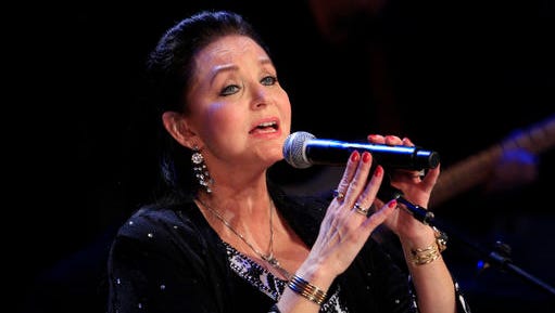 FILE - In this Oct. 21, 2012 file photo, Crystal Gayle performs at the Country Music Hall of Fame Inductions in Nashville, Tenn. Country music legend Gayle is being inducted into the Grand Ole Opry in Nashville, nearly a half-century after she first walked onto its stage to perform as a teenager. Gayle's sister, country luminary Loretta Lynn, will induct her into the country music institution during a Saturday night, Jan. 21, 2017, ceremony at the Ryman Auditorium, the Grand Ole Opry announced.