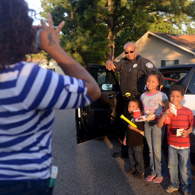 
Dequendal Chapman takes photos of neighborhood children and Jackson Police Officer James Avery during one of the National Night Out events on Lincoln Street Tuesday.
