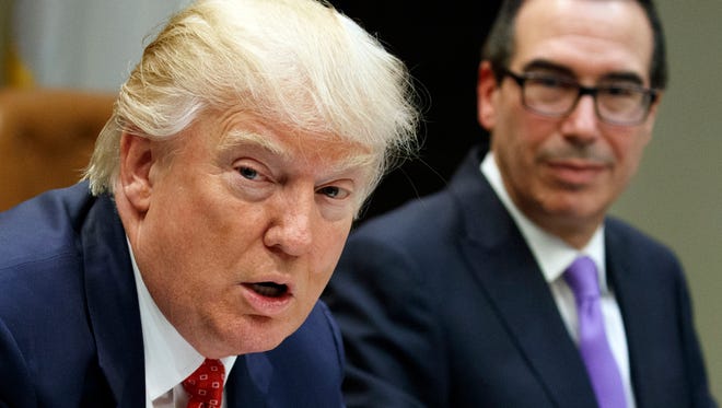 Treasury Secretary Steven Mnuchin (right) listens as President Donald Trump speaks during a meeting on the Federal budget Feb. 22, 2017 in the Roosevelt Room of the White House in Washington. Trump wants to tackle tax reform, but the loss on health care deals a blow to that effort. The loss on health care deprives Republicans of $1 trillion in tax cuts, and the GOP is just as divided on what steps to take.