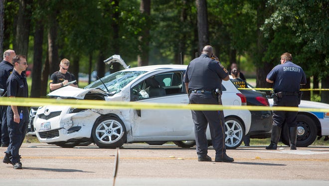 The Harris County Sheriff's Department investigates the scene of a car chase that ended in a fatal shooting Wednesday, April 15, 2015, in Houston. Deputy Thomas Gilliland, said that after the chase, two Houston police officers told the suspect to show his hands, but as they approached his car he reached back into his vehicle. Suspecting that he was reaching for a weapon, both officers opened fire multiple times, killing the man. (Cody Duty/Houston Chronicle via AP)