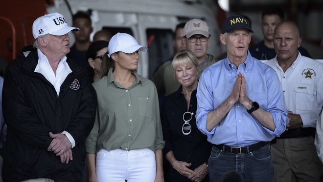 US President Donald Trump (L), First Lady Melania Trump (2nd L) listen to Florida Governor Rick Scott as he speaks during a briefing on Hurricane Irma relief efforts at Southwest Florida International Airport in Fort Myers, Florida, Thursday.
