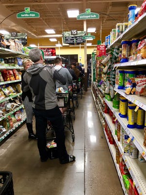 Customers at Kroger, 9440 Brownsboro Road, stand in long lines at 10 p.m. Thursday to stock up on food in hopes to avoid icy weather conditions predicted for Friday’s forecast. 