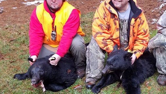Hunter Kann (left) and his father, Jim Kann (right) with the two bears they shot in Potter County.