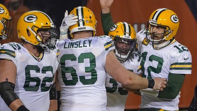 Green Bay Packers' Aaron Jones is congratulated by Aaron Rodgers and Corey Linsley after riunning for a touchdown during the second half of an NFL football game against the Chicago Bears Sunday, Jan. 3, 2021, in Chicago.