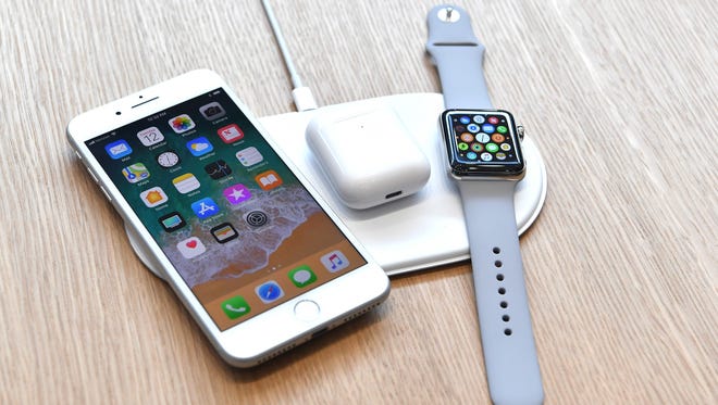 An AirPower mat is seen charging multiple devices.