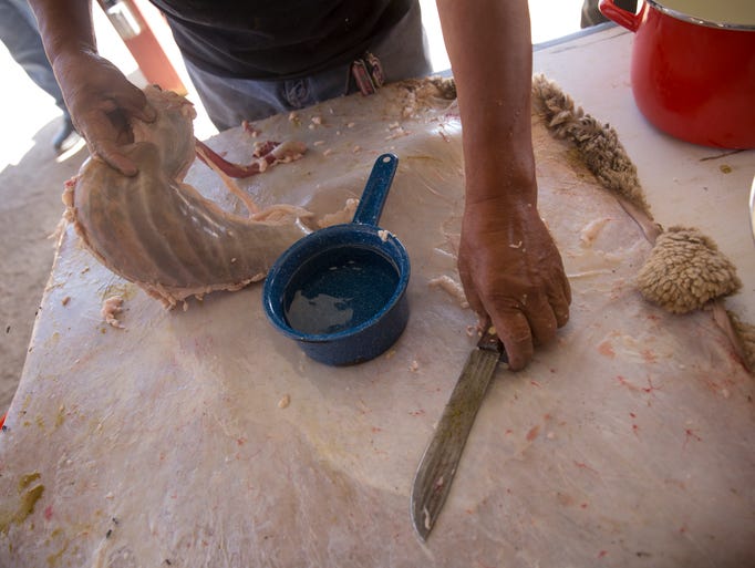 Ron Garnanez cuts and cleans a sheep stomach Wednesday