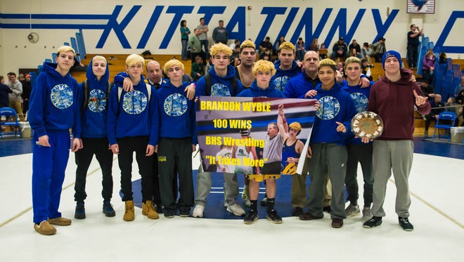 Butler senior Brandon Wyble celebrates with his coaches and teammates after winning his 100th career match and claiming the District 2 126-pound title last weekend at Kittatinny High School.