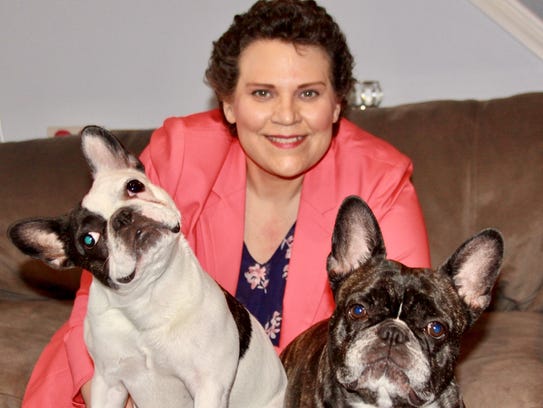 Kimberlie Newton, 45, holds her dogs Stella, left,