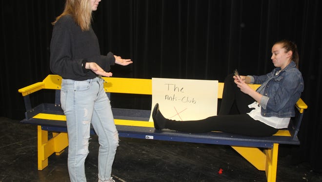 Milly (Liberty Lightfoot, standing) wants to talk with her friend, Cindi (Isabel Schneider), who is too interested in her Smartphone. The bench used in this scene was among two recently presented to English Valleys High School by the class of 1974.