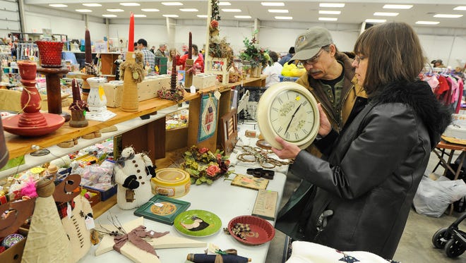 Jerry and Kathy Zychowski of Menomonee Falls look at a wall clock at one of the booths in the Action Reporter Media Ultimate Indoor Garage Sale at the Fond du Lac County Fairgrounds in 2013. Booths are still available for this year’s event on March 7.