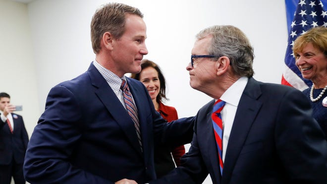 Ohio Attorney General and former U.S. Sen. Mike DeWine, right, shakes hands with Ohio Secretary of State Jon Husted, left, during a news conference at the University of Dayton to announce their decision to share the ticket in their bid for the Ohio governorship, Thursday, Nov. 30, 2017, in Dayton, Ohio. (AP Photo/John Minchillo)