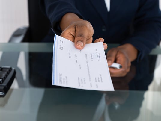 Person's Hand Giving Cheque