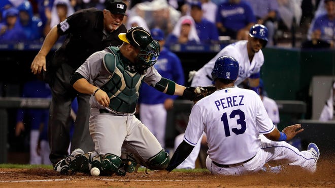 Kansas City Royals catcher Salvador Perez slides safely into home as Oakland Athletics catcher Stephen Vogt drops the ball during the 6th inning at Kauffman Stadium on Tuesday.
