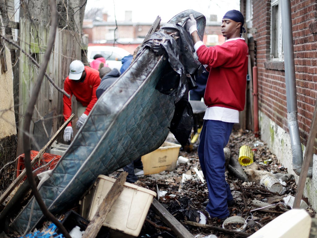 Brandon Nelson helps to clear trash from a vacant house and yard on  Martin Luther King Jr. Day in Memphis. Residents of the city where civil rights leader Martin Luther King Jr. was killed are honoring his legacy with neighborhood clean-up events an