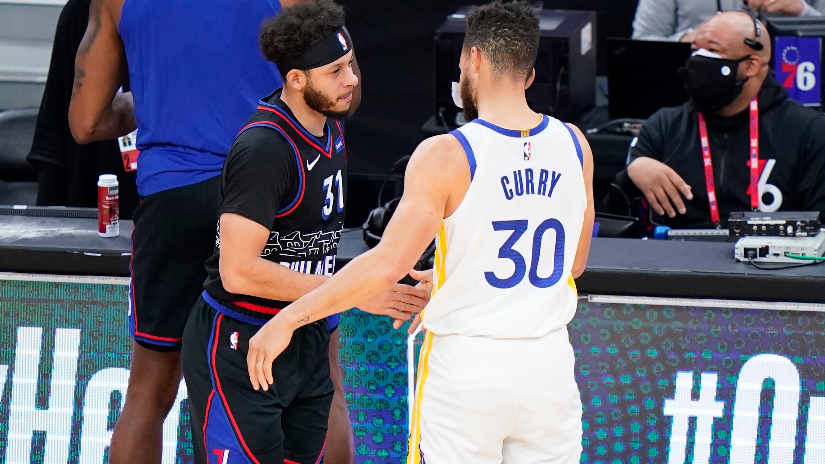 Philadelphia 76ers' Seth Curry, left, and Golden State Warriors' Stephen Curry meet before an NBA basketball game, Monday, April 19, 2021, in Philadelphia. (AP Photo/Matt Slocum)